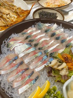 Taze ve narin sashimi dilimleri, canlı renkler ve mükemmel kesimlerle güzelce sunuluyor. Bu geleneksel Japon lezzeti kaliteli deniz ürünlerinin saf tatlarını vurgular..
