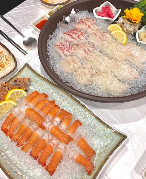 Taze ve narin sashimi dilimleri, canlı renkler ve mükemmel kesimlerle güzelce sunuluyor. Bu geleneksel Japon lezzeti kaliteli deniz ürünlerinin saf tatlarını vurgular..