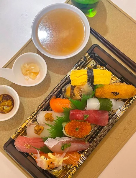 Çeşitli malzemeler ve canlı renklerle sanatsal olarak düzenlenmiş taze suşi çeşitleri. Bu geleneksel Japon yemeği bir deneyim için sirkeli pirinç, deniz ürünleri ve sebzeleri birleştirir..