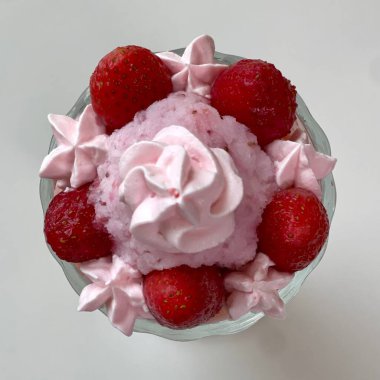 Taze meyveyle yapılmış çilekli parfe ve kırsal beyaz bir masanın üzerinde yoğurt. Bulanık arkaplan ve arkaplan ile seçmeli odak.