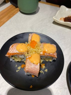 Çeşitli malzemeler ve canlı renklerle sanatsal olarak düzenlenmiş taze suşi çeşitleri. Bu geleneksel Japon yemeği bir deneyim için sirkeli pirinç, deniz ürünleri ve sebzeleri birleştirir..