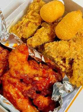 Kızarmış Kore tavuğu, tatlı ve baharatlı sosla mükemmel bir şekilde jölelenmiş. Yemek fotoğrafçılığı ve menüler için idealdir. Bu sevilen yemeğin dayanılmaz çıtırtısını ve lezzetini sergiler..