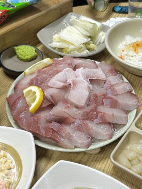 Taze ve tereyağlı sarı kuyruklu sashimi (bangeo) zengin, ağzında eriyen bir dokuya sahip, temiz tatların mükemmel bir dengesi ve her lüks ısırıkta tatlı bir tat sunar..