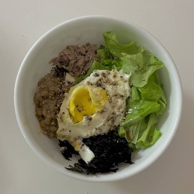 Bibimbap, çeşitli sebzeler, gochujang ve sıklıkla dilimlenmiş etin eşlik ettiği kızarmış yumurta ile süslenmiş canlı bir Kore pirinç yemeği. Karıştırıldığında, aromalı ve dengeli olur..