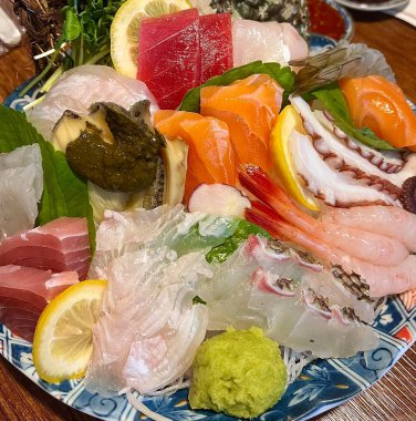 Taze ve narin sashimi dilimleri, canlı renkler ve mükemmel kesimlerle güzelce sunuluyor. Bu geleneksel Japon lezzeti kaliteli deniz ürünlerinin saf tatlarını vurgular..