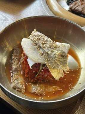 Chilled, chewy naengmyeon noodles in tangy broth paired with juicy, savory mandu dumplings, offering a perfect balance of refreshing coolness and hearty comfort in every delicious Korean bite.
