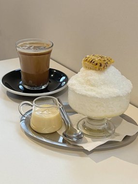 Refreshing bingsu, a Korean shaved ice dessert topped with sweet ingredients like red beans, fruits, and condensed milk. A perfect treat to cool down on hot days.