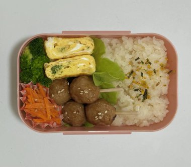 Geleneksel bir Kore dozirak 'ı. Pirinç, çeşitli banchan ve tuzlu proteinlerle güzelce düzenlenmiş. Dengeli ve görsel olarak davetkâr, canlı lezzetlerle dolu taşınabilir bir yemek..