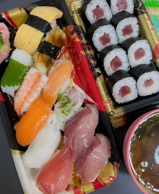 Çeşitli malzemeler ve canlı renklerle sanatsal olarak düzenlenmiş taze suşi çeşitleri. Bu geleneksel Japon yemeği bir deneyim için sirkeli pirinç, deniz ürünleri ve sebzeleri birleştirir..