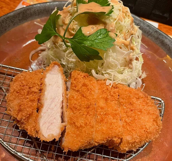 Çıtır tonkatsu, Japon usulü kızarmış domuz pirzolası dilimlenmiş lahana ve tuzlu sosla servis edilir. Lezzetli bir kıtır kıtır doku ve sulu et dengesi.