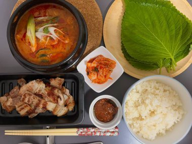 Warm and comforting jibbap (home-cooked Korean meal) with a spread of rice, soup, and banchan, offering a perfect harmony of flavor, tradition, and heartwarming nourishment in every bite.