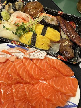 Taze ve narin sashimi dilimleri, canlı renkler ve mükemmel kesimlerle güzelce sunuluyor. Bu geleneksel Japon lezzeti kaliteli deniz ürünlerinin saf tatlarını vurgular..