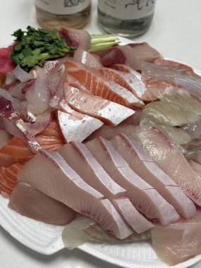 Taze ve narin sashimi dilimleri, canlı renkler ve mükemmel kesimlerle güzelce sunuluyor. Bu geleneksel Japon lezzeti kaliteli deniz ürünlerinin saf tatlarını vurgular..