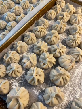 Steamed xiaolongbao dumplings with delicate thin skin, slightly translucent top folds, and savory soup filling inside, highlighting their soft texture and freshly steamed appearance in close-up detail