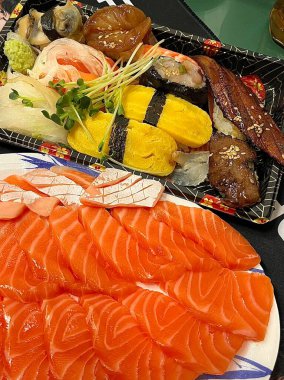 Taze ve narin sashimi dilimleri, canlı renkler ve mükemmel kesimlerle güzelce sunuluyor. Bu geleneksel Japon lezzeti kaliteli deniz ürünlerinin saf tatlarını vurgular..