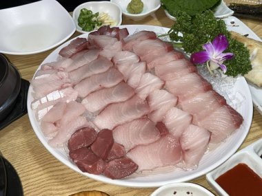 Taze ve narin sashimi dilimleri, canlı renkler ve mükemmel kesimlerle güzelce sunuluyor. Bu geleneksel Japon lezzeti kaliteli deniz ürünlerinin saf tatlarını vurgular..
