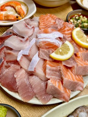 Taze ve narin sashimi dilimleri, canlı renkler ve mükemmel kesimlerle güzelce sunuluyor. Bu geleneksel Japon lezzeti kaliteli deniz ürünlerinin saf tatlarını vurgular..