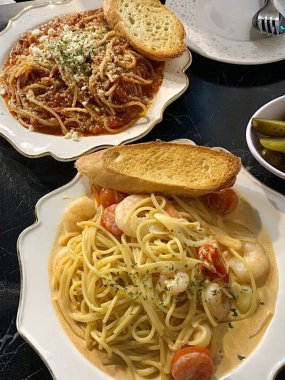 Lezzetli beyaz bir sosla kaplanmış kremalı ve zengin spagetti rahatlatıcı ve tatmin edici bir yemek için mükemmel bir lezzet sunuyor..