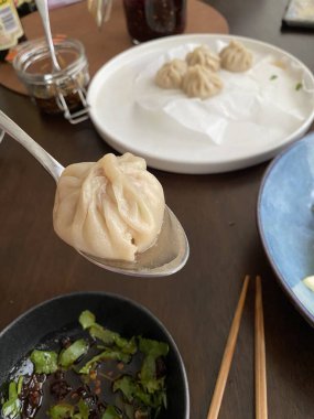 Steamed xiaolongbao dumplings with delicate thin skin, slightly translucent top folds, and savory soup filling inside, highlighting their soft texture and freshly steamed appearance in close-up detail