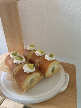 A soft, fluffy roll cake with a delicate sponge and creamy filling, perfect for a light dessert or afternoon snack. A sweet, indulgent treat with a smooth texture and rich flavor.