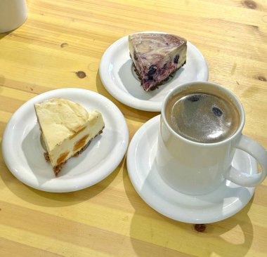 Hoş bir kafe ortamında sergilenen tatlı çeşitleri zarif tabaklar üzerinde pastalar, pastalar ve tatlı ikramlar, sıcak ve davetkar bir atmosfer yaratıyor..