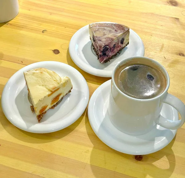 Hoş bir kafe ortamında sergilenen tatlı çeşitleri zarif tabaklar üzerinde pastalar, pastalar ve tatlı ikramlar, sıcak ve davetkar bir atmosfer yaratıyor..