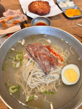 Soğukta çiğnenmiş karabuğday erişteli otantik Pyongyang naengmyeonu taze ve lezzetli bir tat sunuyor. Geleneksel Kore mutfak menüleri ve yaz yemekleri için mükemmel..