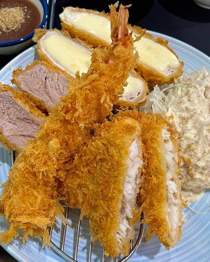 Erimiş peynirle doldurulmuş çıtır tonkatsu pirzolası, kıtır kıtır ve kremanın lezzetli bir karışımını oluşturuyor. Zengin ve altın kaplamalı rahatlatıcı bir yemek..