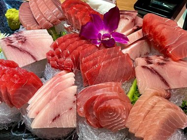 Taze ve narin sashimi dilimleri, canlı renkler ve mükemmel kesimlerle güzelce sunuluyor. Bu geleneksel Japon lezzeti kaliteli deniz ürünlerinin saf tatlarını vurgular..