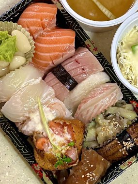 Çeşitli malzemeler ve canlı renklerle sanatsal olarak düzenlenmiş taze suşi çeşitleri. Bu geleneksel Japon yemeği bir deneyim için sirkeli pirinç, deniz ürünleri ve sebzeleri birleştirir..