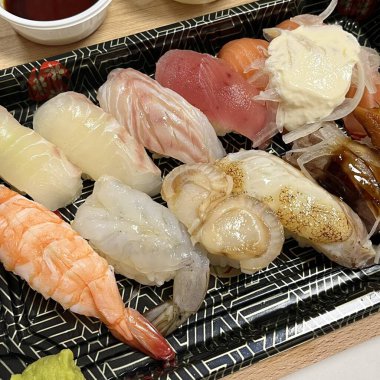 Çeşitli malzemeler ve canlı renklerle sanatsal olarak düzenlenmiş taze suşi çeşitleri. Bu geleneksel Japon yemeği bir deneyim için sirkeli pirinç, deniz ürünleri ve sebzeleri birleştirir..