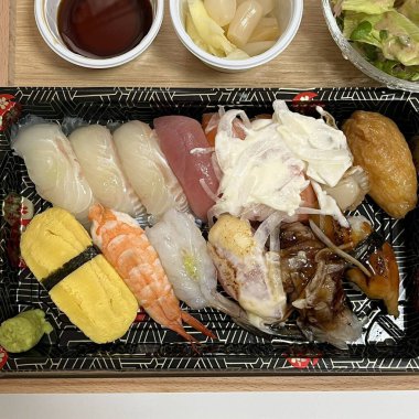 Çeşitli malzemeler ve canlı renklerle sanatsal olarak düzenlenmiş taze suşi çeşitleri. Bu geleneksel Japon yemeği bir deneyim için sirkeli pirinç, deniz ürünleri ve sebzeleri birleştirir..