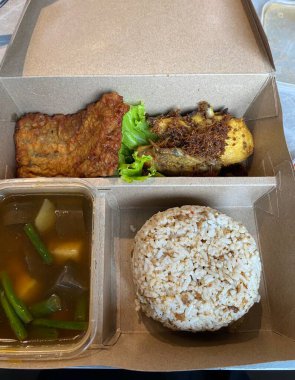 Nasi kampü, Endonezya 'nın klasik bir yemeği. Kızarmış tavuk, sambal, sebze ve tempeh gibi çeşitli tatlandırıcı içerikli pirinç içeriyor. Endonezya lezzetlerini kutlayan canlı, dengeli bir yemek..