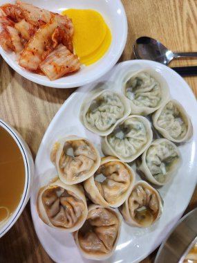 Mayalanmış kimchi ile birlikte haşlanmış ya da kızartılmış mandu köftesi. Lezzetli, taze hamur köftelerini baharatlı, keskin ve aromalı sebzelerle birleştiren klasik bir Kore çifti yaratıyor.