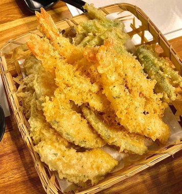 Hafif altın hamurlu gevrek tempura, içinde hassas kıtır kıtır dokular ve hassas malzemeler sergiliyor, havadar tabakasını ve iştah açıcı görünümünü yakından gösteriyor.