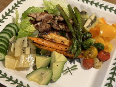 Taze salata taze yapraklı sebzeler, dilimlenmiş sebzeler ve rengarenk malzemelerin karışımı sağlıklı, canlı ve ferahlatıcı bir tat yaratmak için bir araya getirilmiş.