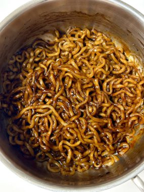 Yeşil soğan ve susamlı fasulye soslu baharatlı japagetti eriştesi. Her ısırıkta derinlik ve lezzeti birleştiren rahatlatıcı bir Kore favorisi..