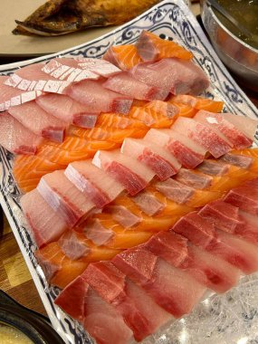 Taze ve narin sashimi dilimleri, canlı renkler ve mükemmel kesimlerle güzelce sunuluyor. Bu geleneksel Japon lezzeti kaliteli deniz ürünlerinin saf tatlarını vurgular..