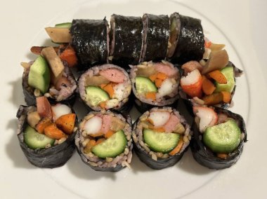 Taze sebzelerle, baharatlı pirinçlerle ve gevrek yosunlara sarılmış lezzetli proteinlerle dolu nefis kimbap dürümleri. Her ısırıkta lezzet ve dokuların mükemmel bir kombinasyonu.