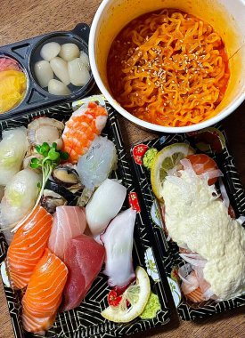 Çeşitli malzemeler ve canlı renklerle sanatsal olarak düzenlenmiş taze suşi çeşitleri. Bu geleneksel Japon yemeği bir deneyim için sirkeli pirinç, deniz ürünleri ve sebzeleri birleştirir..