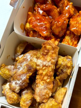 Kızarmış Kore tavuğu, tatlı ve baharatlı sosla mükemmel bir şekilde jölelenmiş. Yemek fotoğrafçılığı ve menüler için idealdir. Bu sevilen yemeğin dayanılmaz çıtırtısını ve lezzetini sergiler..