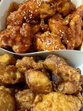 Kızarmış Kore tavuğu, tatlı ve baharatlı sosla mükemmel bir şekilde jölelenmiş. Yemek fotoğrafçılığı ve menüler için idealdir. Bu sevilen yemeğin dayanılmaz çıtırtısını ve lezzetini sergiler..