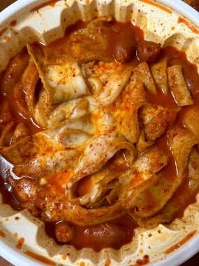 Chewy rose yeotteok coated in spicy pink sauce paired with a crispy corndog, blending sweet, savory, and spicy flavors. A trendy Korean street food duo perfect for food promotions.