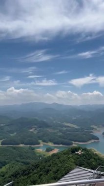 Yeşil dağların ya da açık arazilerin üzerine uzanan açık gökyüzü huzurlu bir doğal manzara yaratıyor. Temiz hava ve uçsuz bucaksız manzara huzuru ve doğayla bağlantıyı çağrıştırıyor..