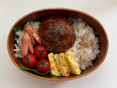 Geleneksel bir Kore dozirak 'ı. Pirinç, çeşitli banchan ve tuzlu proteinlerle güzelce düzenlenmiş. Dengeli ve görsel olarak davetkâr, canlı lezzetlerle dolu taşınabilir bir yemek..