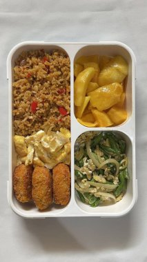 Geleneksel bir Kore dozirak 'ı. Pirinç, çeşitli banchan ve tuzlu proteinlerle güzelce düzenlenmiş. Dengeli ve görsel olarak davetkâr, canlı lezzetlerle dolu taşınabilir bir yemek..