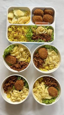 Geleneksel bir Kore dozirak 'ı. Pirinç, çeşitli banchan ve tuzlu proteinlerle güzelce düzenlenmiş. Dengeli ve görsel olarak davetkâr, canlı lezzetlerle dolu taşınabilir bir yemek..