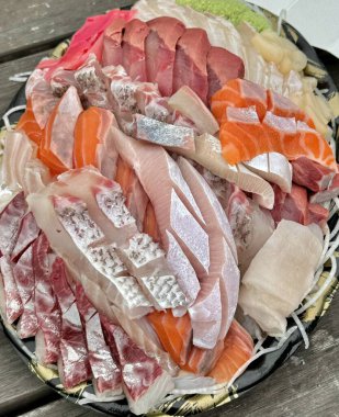 Taze ve narin sashimi dilimleri, canlı renkler ve mükemmel kesimlerle güzelce sunuluyor. Bu geleneksel Japon lezzeti kaliteli deniz ürünlerinin saf tatlarını vurgular..