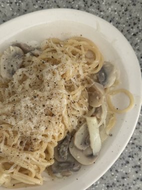 Lezzetli beyaz bir sosla kaplanmış kremalı ve zengin spagetti rahatlatıcı ve tatmin edici bir yemek için mükemmel bir lezzet sunuyor..