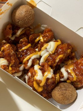 Kızarmış Kore tavuğu, tatlı ve baharatlı sosla mükemmel bir şekilde jölelenmiş. Yemek fotoğrafçılığı ve menüler için idealdir. Bu sevilen yemeğin dayanılmaz çıtırtısını ve lezzetini sergiler..